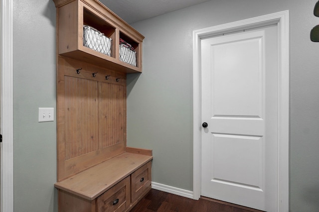 mudroom with dark wood-style floors and baseboards