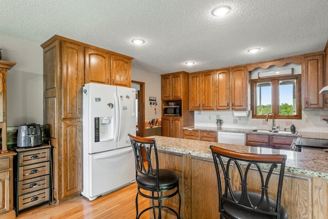 4949 S 196th Rd, Halfway, MO 65663 - kitchen with white appliances, a sink, a textured ceiling, light wood-style floors, and brown cabinetry