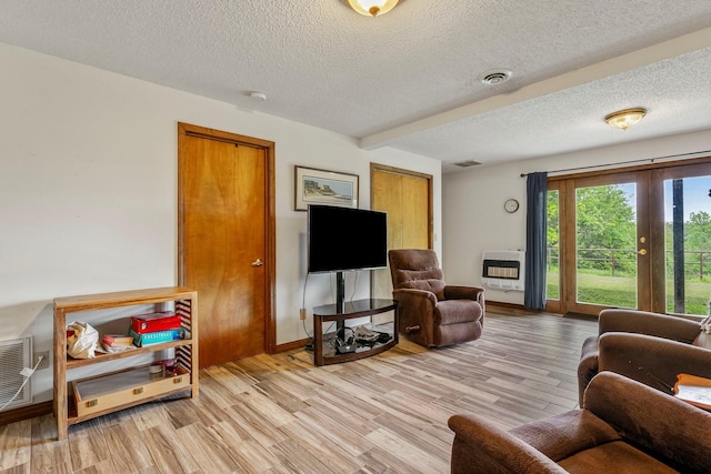 4949 S 196th Rd, Halfway, MO 65663 - living room featuring heating unit, a textured ceiling, light wood-type flooring, and baseboards