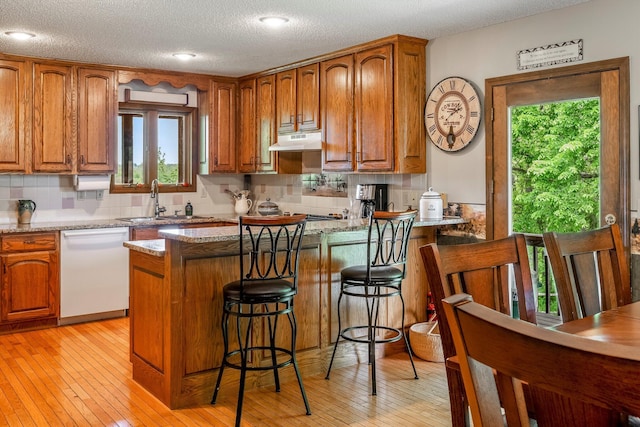 4949 S 196th Rd, Halfway, MO 65663 - kitchen with white dishwasher, under cabinet range hood, a sink, brown cabinets, and a textured ceiling