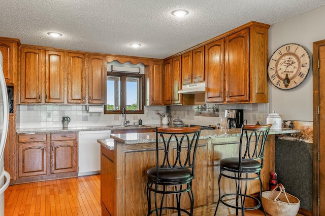 4949 S 196th Rd, Halfway, MO 65663 - kitchen featuring white dishwasher, a sink, under cabinet range hood, a peninsula, and brown cabinets