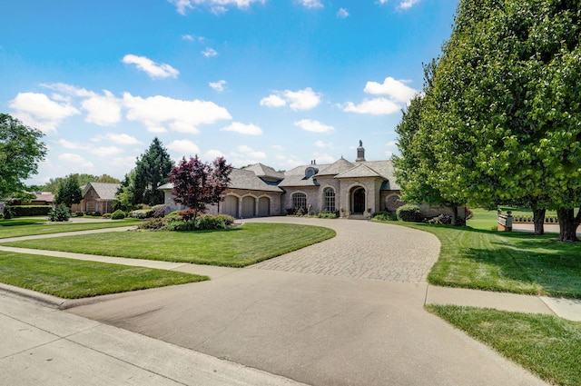 5245 S Stonehaven Dr, Springfield, MO 65809 - french country home with curved driveway, a front yard, a chimney, and stone siding