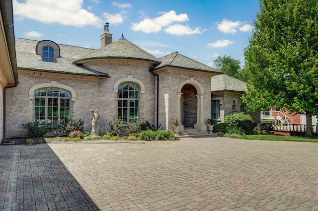 5245 S Stonehaven Dr, Springfield, MO 65809 - french country inspired facade featuring a high end roof, brick siding, and a chimney