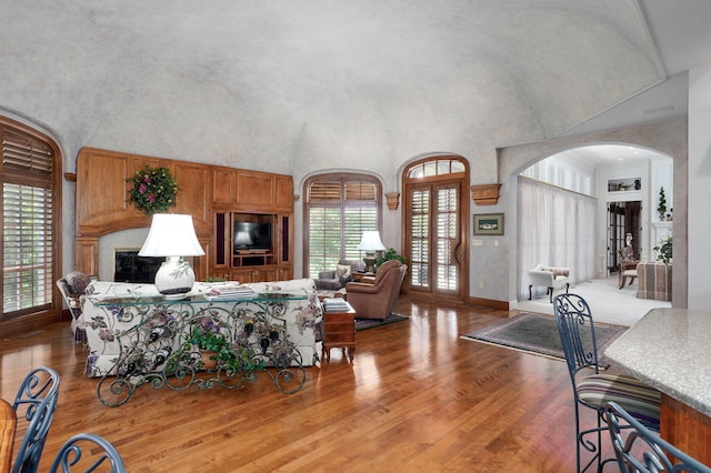 5245 S Stonehaven Dr, Springfield, MO 65809 - living room featuring a high ceiling, arched walkways, wood finished floors, and baseboards