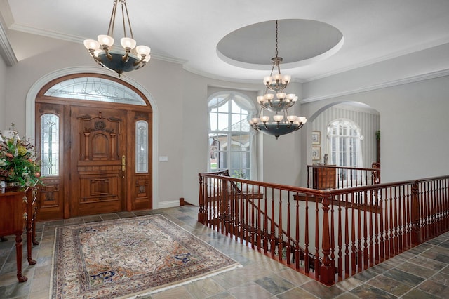5245 S Stonehaven Dr, Springfield, MO 65809 - foyer with a chandelier, stone tile flooring, ornamental molding, arched walkways, and baseboards
