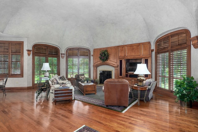 5245 S Stonehaven Dr, Springfield, MO 65809 - living room featuring healthy amount of natural light, a towering ceiling, light wood-type flooring, a high end fireplace, and baseboards