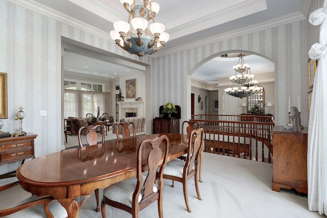 5245 S Stonehaven Dr, Springfield, MO 65809 - dining space featuring wallpapered walls, a chandelier, arched walkways, crown molding, and a fireplace