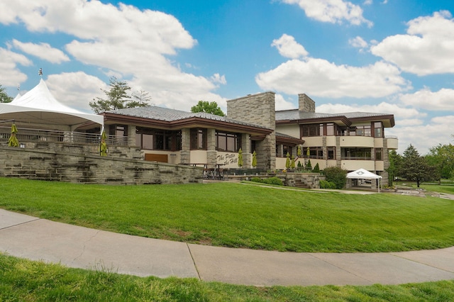 5245 S Stonehaven Dr, Springfield, MO 65809 - back of house with a chimney, a yard, and stone siding