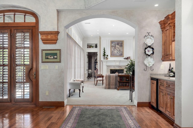 5245 S Stonehaven Dr, Springfield, MO 65809 - entryway with wood finished floors, arched walkways, a high end fireplace, baseboards, and crown molding
