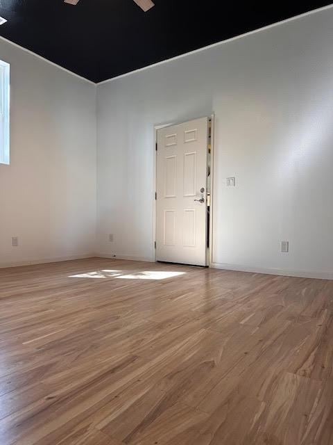unfurnished room with light wood finished floors and baseboards