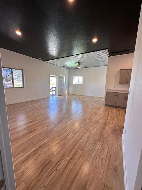 spare room featuring a ceiling fan, light wood-style flooring, healthy amount of natural light, and recessed lighting