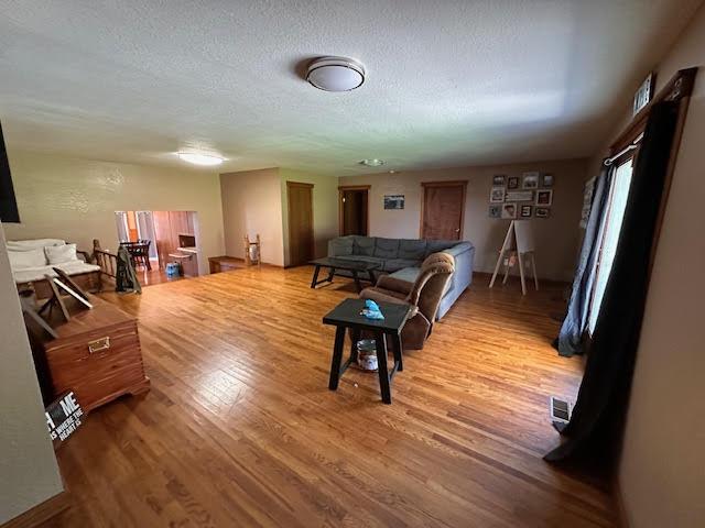 living area with wood finished floors and a textured ceiling