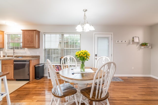 dining room featuring light wood-style floors, a chandelier, and baseboards