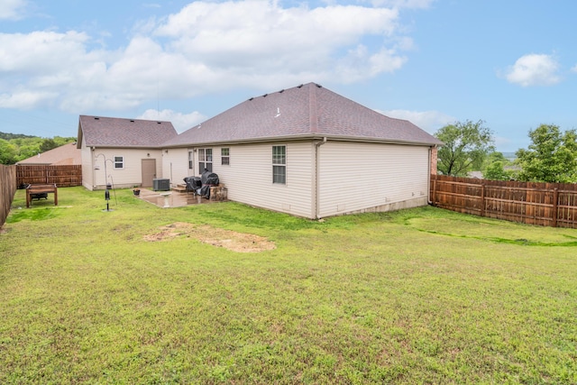 back of house featuring cooling unit, a patio area, and roof with shingles