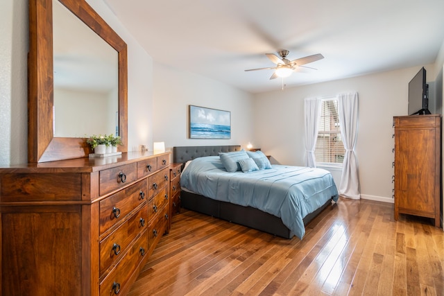 bedroom featuring light wood finished floors and baseboards