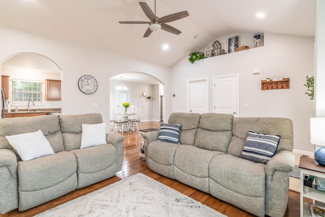 living area featuring arched walkways, ceiling fan, wood finished floors, high vaulted ceiling, and recessed lighting