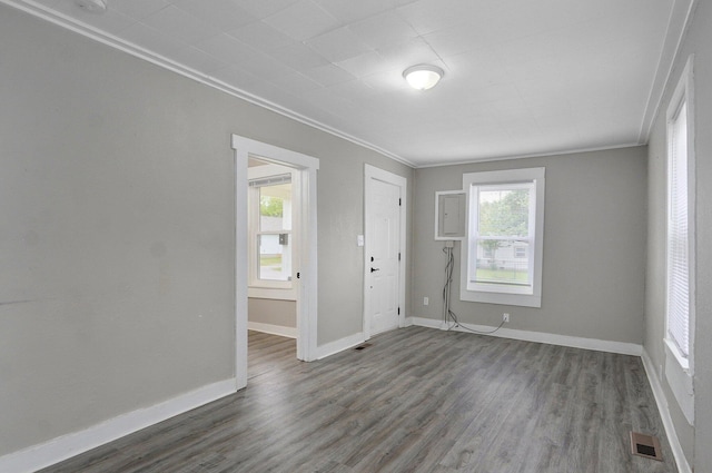 spare room with ornamental molding, wood finished floors, and baseboards