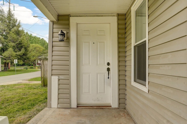 doorway to property featuring a lawn