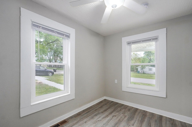 empty room with wood finished floors, baseboards, a smoke detector, and a ceiling fan