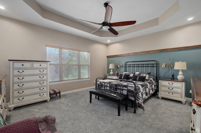 carpeted bedroom with baseboards, recessed lighting, a tray ceiling, and ceiling fan