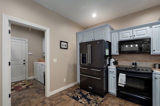 kitchen with black appliances, washing machine and clothes dryer, tasteful backsplash, light countertops, and baseboards