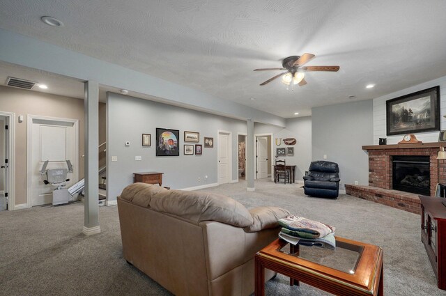 living room featuring carpet floors, ceiling fan, a brick fireplace, baseboards, and recessed lighting