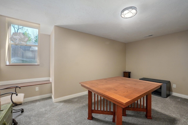 carpeted dining space with baseboards