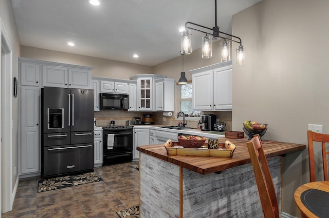 kitchen with black appliances, a sink, white cabinetry, a peninsula, and recessed lighting