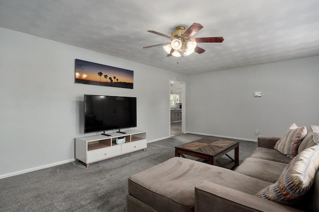 living room featuring a ceiling fan, baseboards, and carpet floors