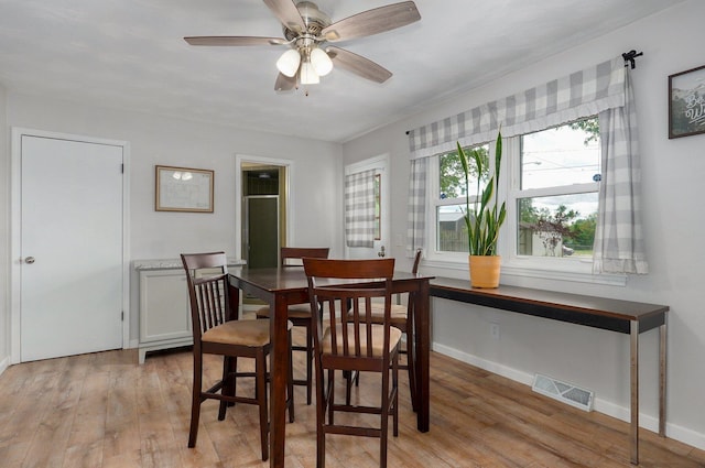 dining room featuring light wood-style flooring, ceiling fan, and baseboards