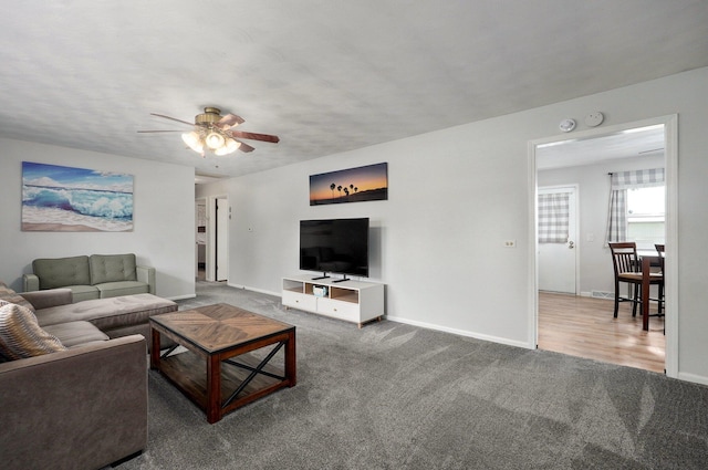 living area featuring a ceiling fan, carpet flooring, and baseboards