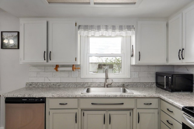 kitchen featuring dishwasher, a sink, tasteful backsplash, and light countertops