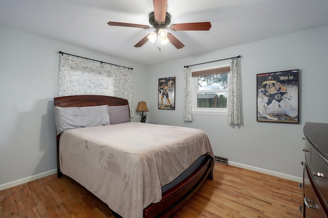 bedroom with baseboards, wood finished floors, and ceiling fan