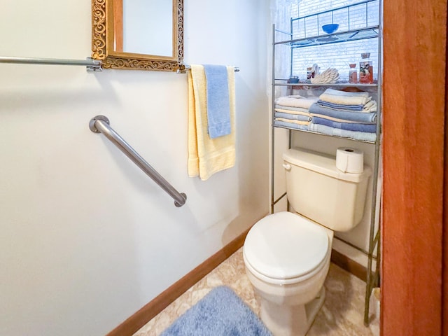 bathroom featuring toilet and baseboards