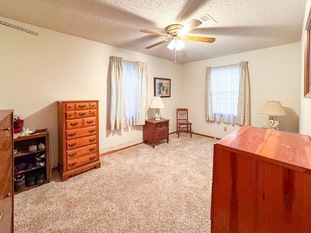 bedroom with light colored carpet, baseboards, a textured ceiling, and ceiling fan