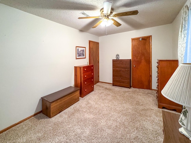 carpeted bedroom with ceiling fan, a textured ceiling, and baseboards