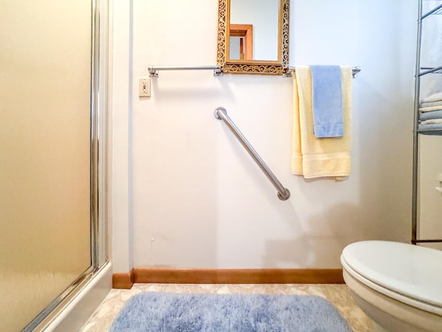 bathroom with baseboards, toilet, and an enclosed shower