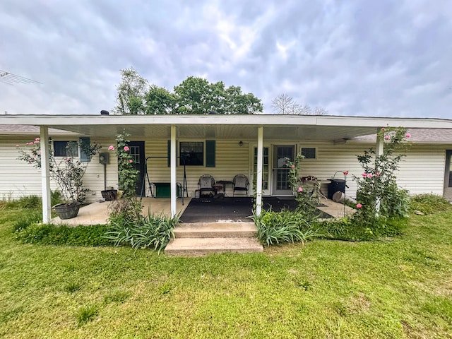 rear view of house with a yard and covered porch