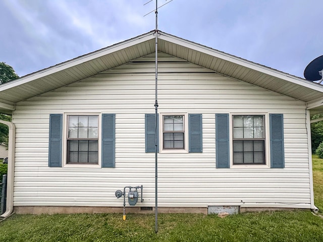 view of property exterior with a lawn and crawl space