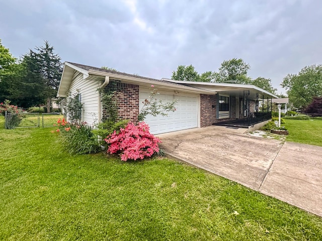 view of side of property with driveway, a garage, brick siding, and covered porch