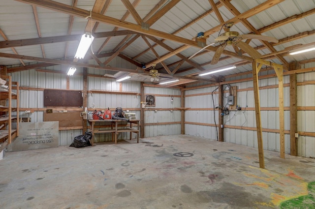 misc room with metal wall, a garage, lofted ceiling, and concrete floors