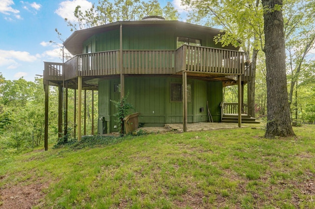 rear view of property with a wooden deck and a lawn