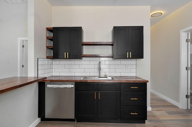 kitchen with open shelves, butcher block counters, a sink, dishwasher, and baseboards