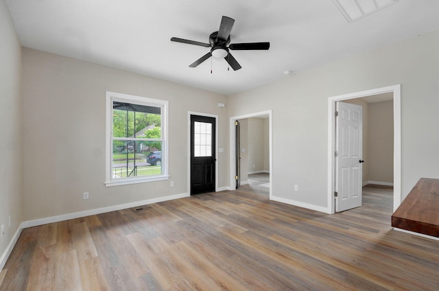 foyer entrance featuring wood finished floors, baseboards, and a ceiling fan