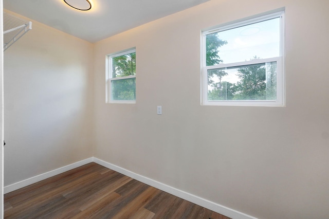 empty room with baseboards and dark wood-style flooring