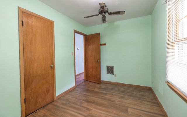 unfurnished bedroom with wood finished floors, baseboards, and a ceiling fan