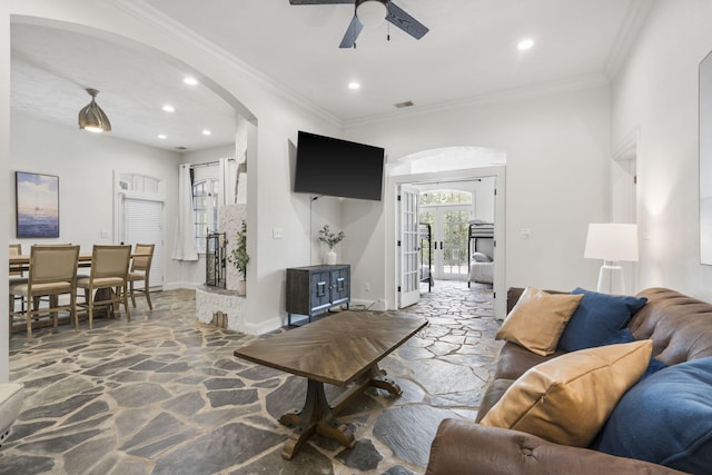 living room featuring stone flooring, arched walkways, a ceiling fan, recessed lighting, and baseboards