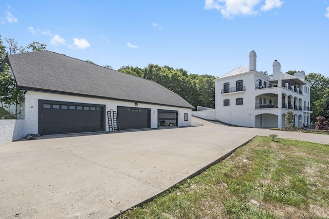 view of side of home with driveway, a garage, and stucco siding