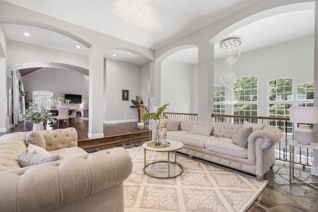 living area featuring arched walkways, recessed lighting, a chandelier, and baseboards