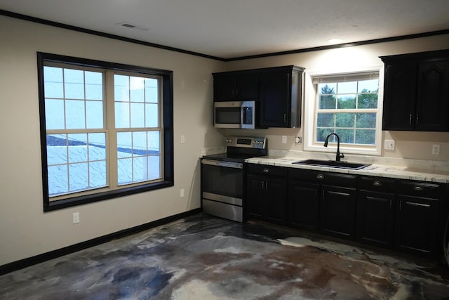 kitchen with appliances with stainless steel finishes, a sink, dark cabinets, ornamental molding, and light countertops